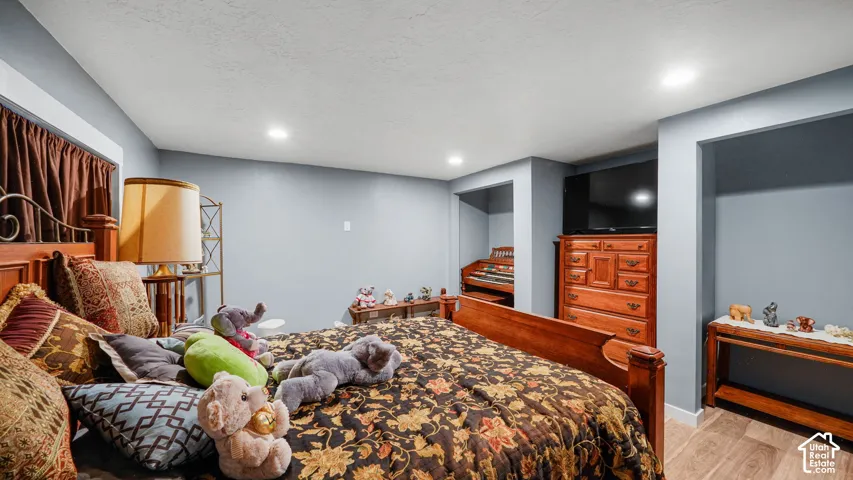Recessed lighting illuminates the room with wood-finish flooring