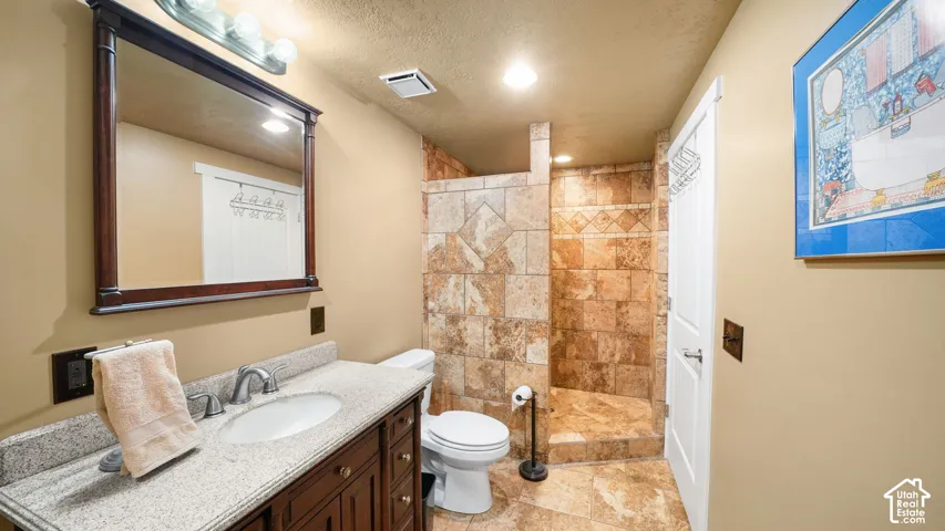 Vanity with a light-toned countertop, undermount sink, and wood-finish cabinetry
