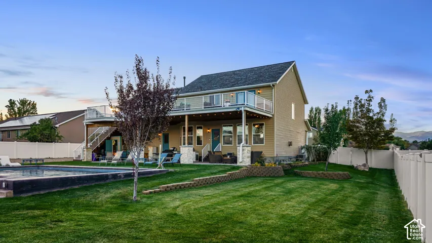 Expansive backyard with a swimming pool, two-story deck, and manicured lawn