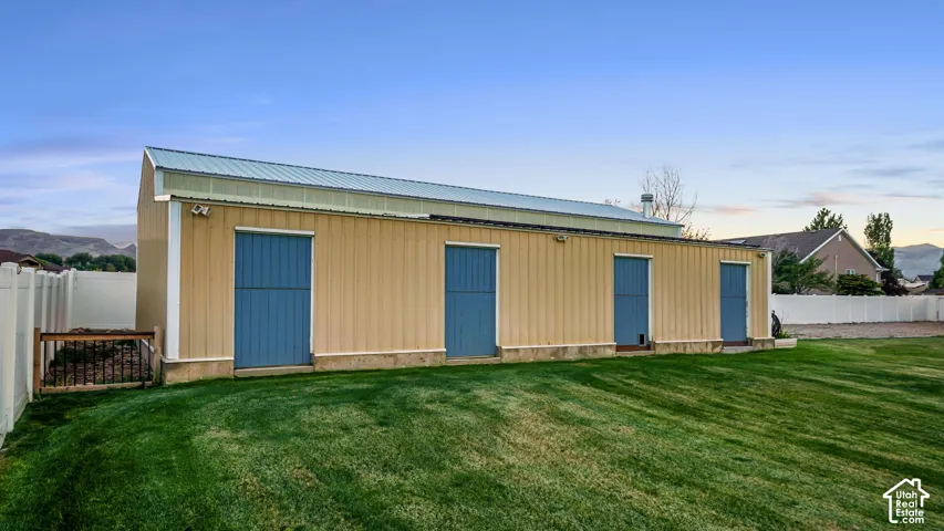 Detached outbuilding with a metal roof, corrugated siding, and multiple access doors