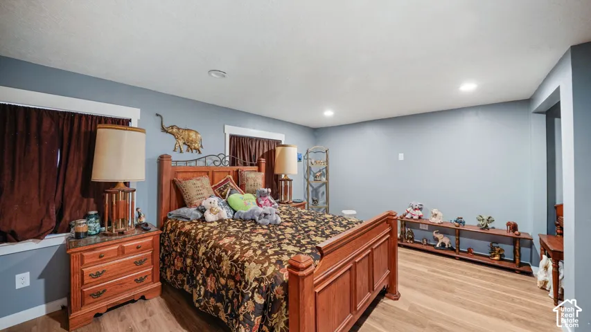 Recessed lighting, wood-finish flooring, and light blue walls