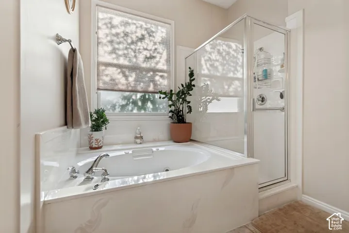 Built-in bathtub with polished chrome fixtures, surrounded by a light-toned enclosure