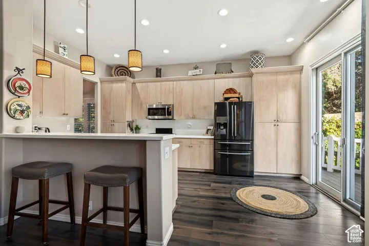 Kitchen featuring wood-finish flooring, light-toned cabinetry, a built-in microwave, and a black French door refrigerator