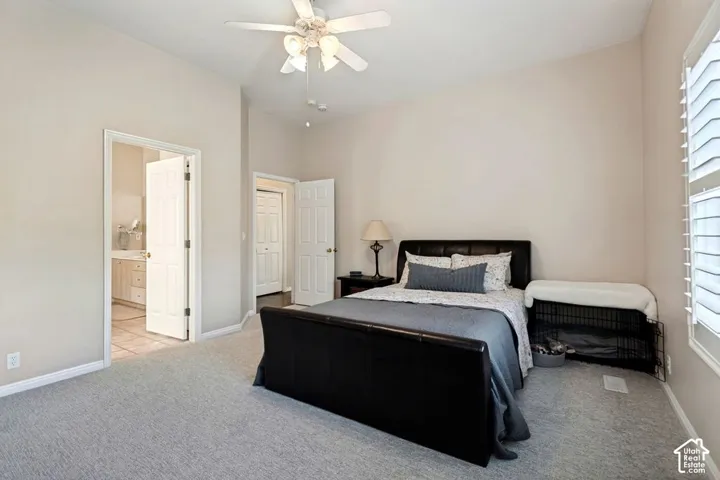 Vaulted ceiling, ceiling fan, carpeted flooring, interior doors, and window with white shutters