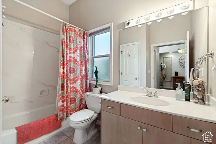 Vanity with light wood-finish cabinetry, white countertop, and integrated sink