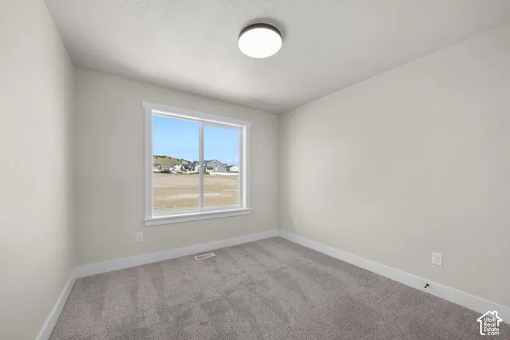 Light-colored walls with a window featuring white trim