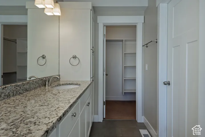 Vanity with granite countertop, integrated sink, and brushed nickel fixtures