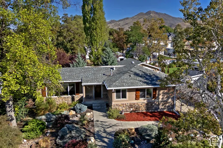 Single-story residence featuring a stone and stucco exterior, prominent entryway, and a gabled roofline