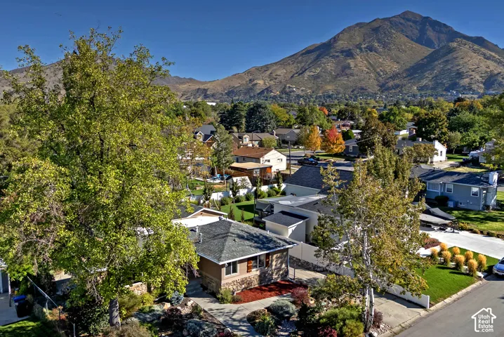 Mountain backdrop with varied terrain, mature trees, and a residential community