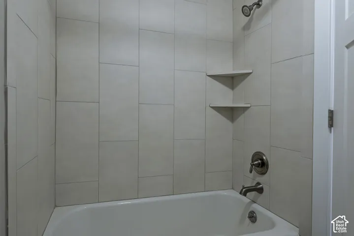 White porcelain tub with a brushed nickel showerhead, faucet, and drain