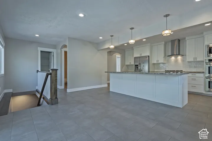 Spacious kitchen with white cabinetry, granite-finish countertops, stainless steel appliances, and a subway tile backsplash