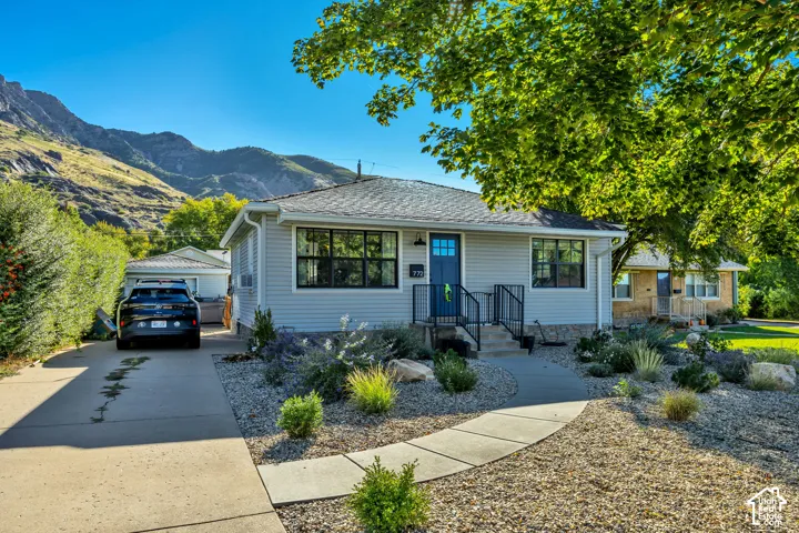 Light gray siding exterior with a dark blue entry door and black window frames