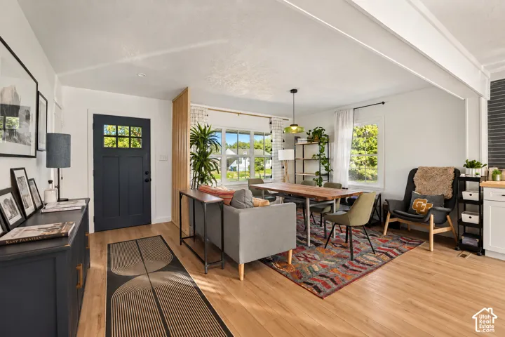Open-concept living space featuring wood-finish flooring, white walls, and multiple windows