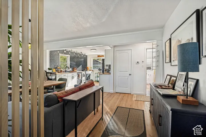 Open-concept living area featuring wood-finish flooring, white walls, and a wood slat partition