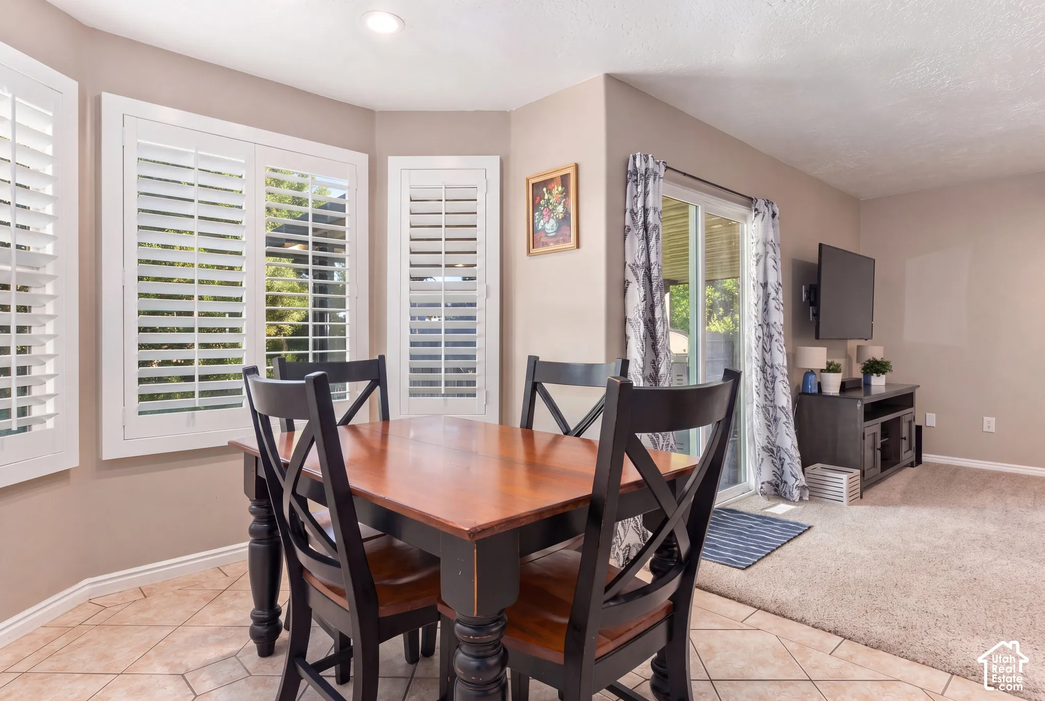 Bay window with plantation shutters, recessed lighting, and tile flooring