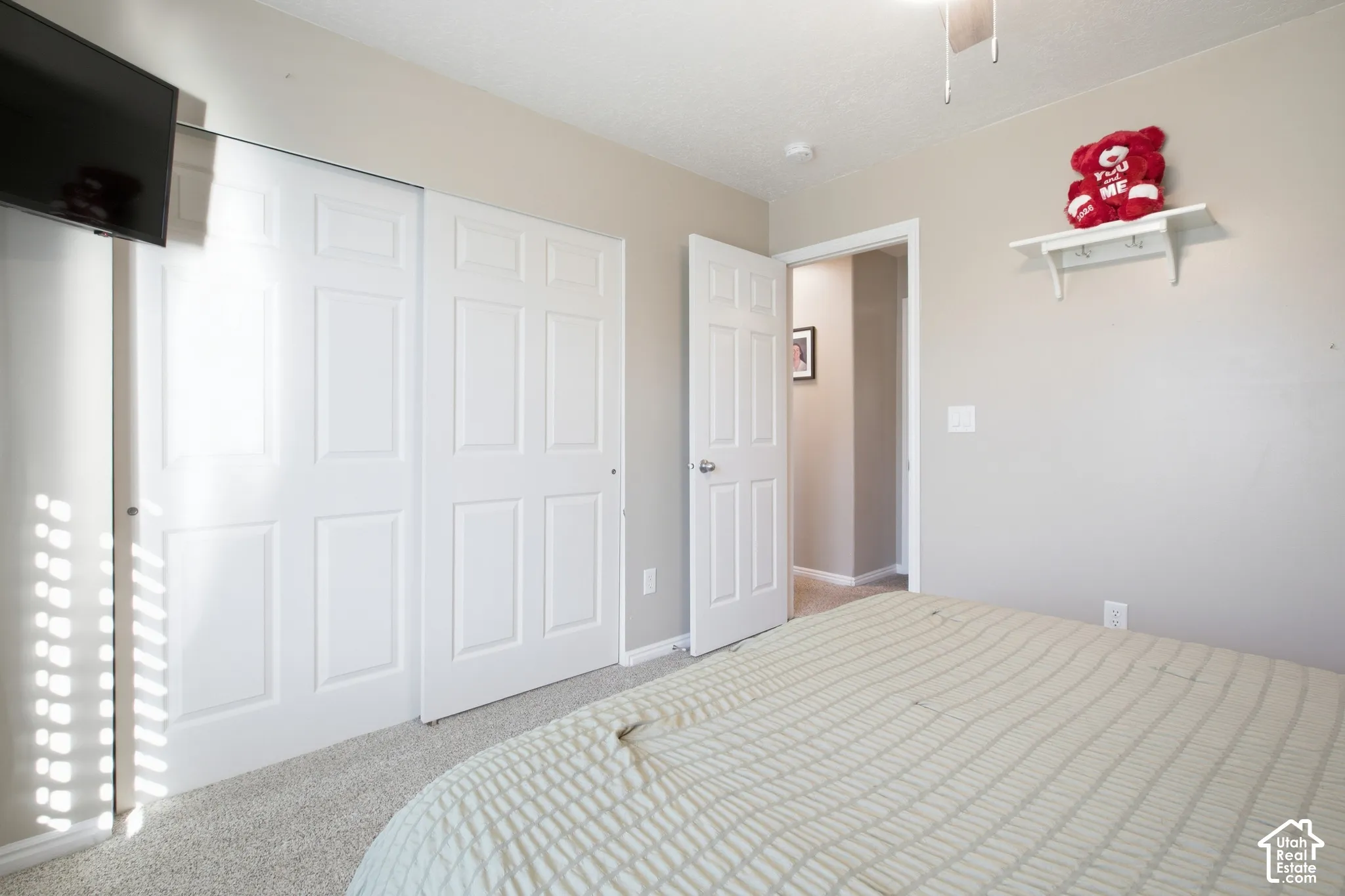 Carpeted flooring, white six-panel closet doors, ceiling fan, and painted walls