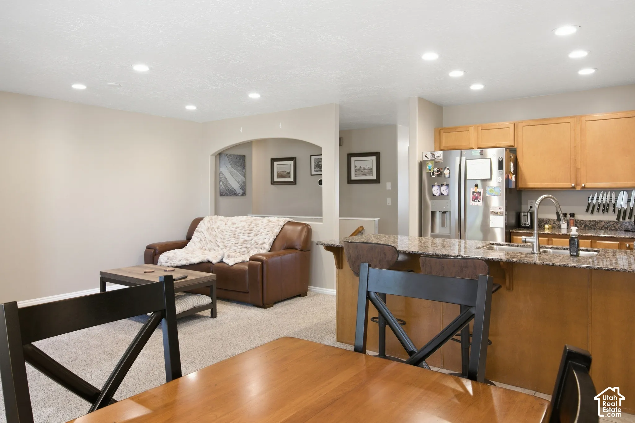 Kitchen with stainless steel refrigerator, undermount sink, and wood cabinetry