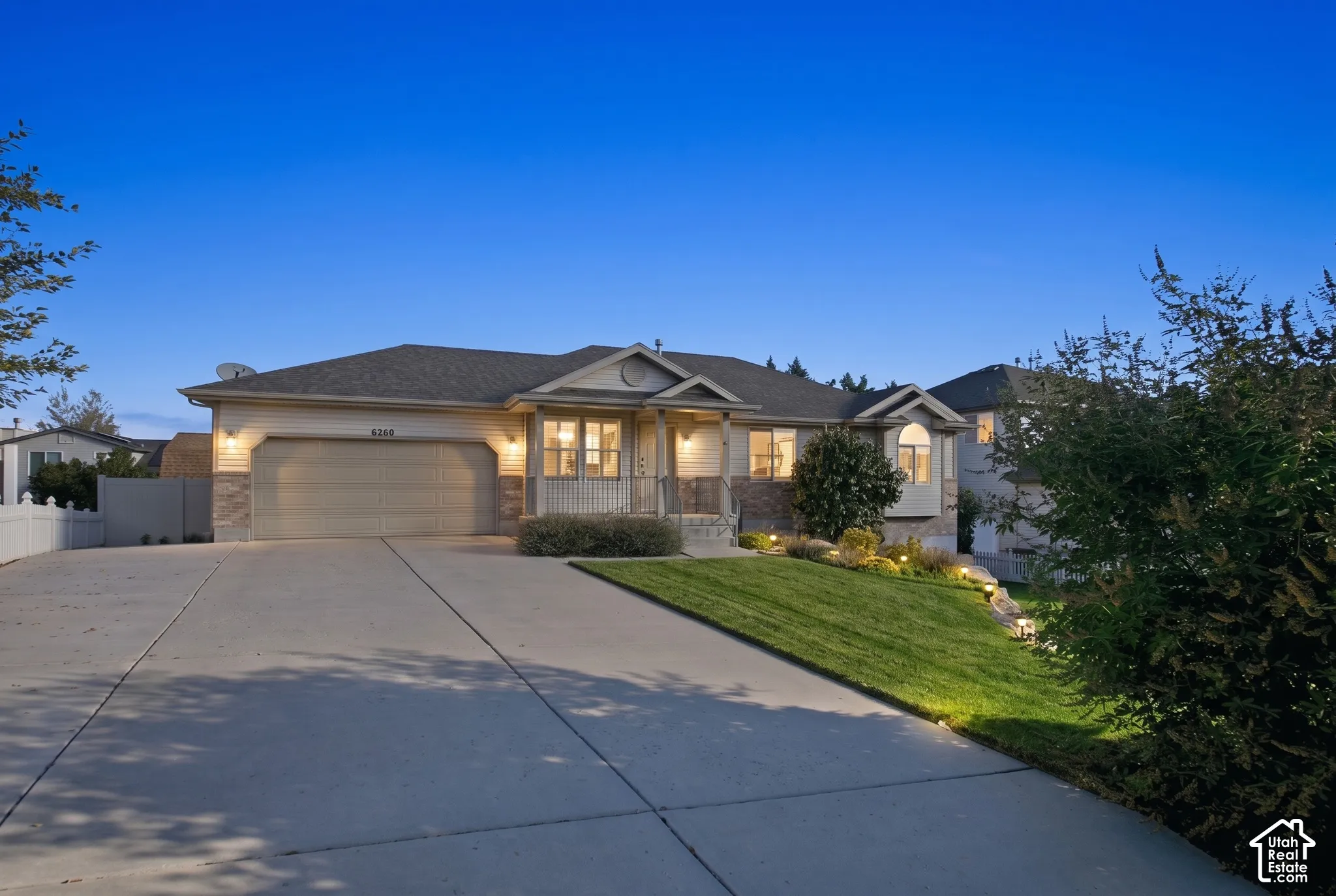 Ranch-style residence featuring a prominent two-car garage, stone and siding exterior, and a concrete driveway