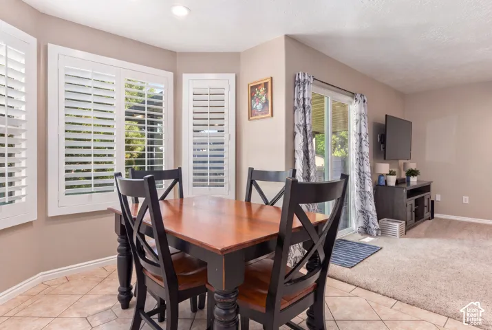 Bay window with plantation shutters, recessed lighting, and tile flooring