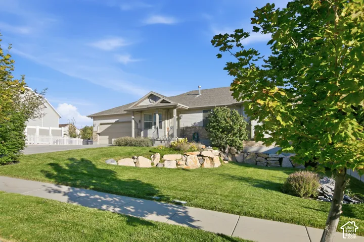 Single-story residence with a covered entry, attached garage, and stone accent siding