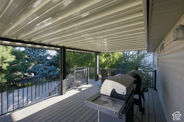 Spacious covered deck featuring composite decking, black metal railings, and a soffit-style ceiling