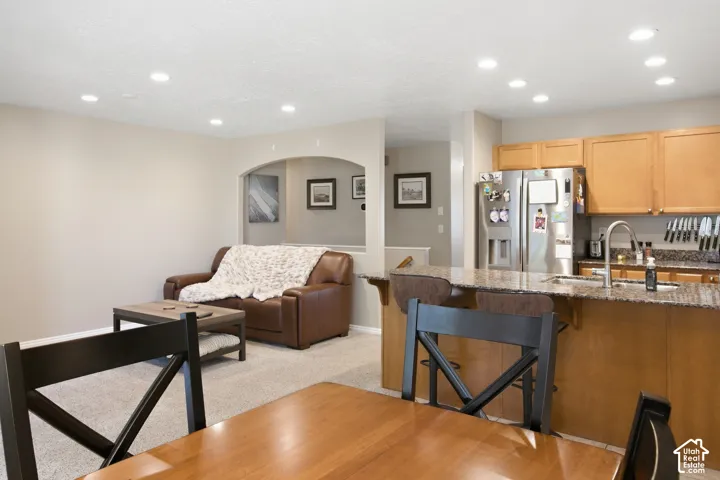 Kitchen with stainless steel refrigerator, undermount sink, and wood cabinetry
