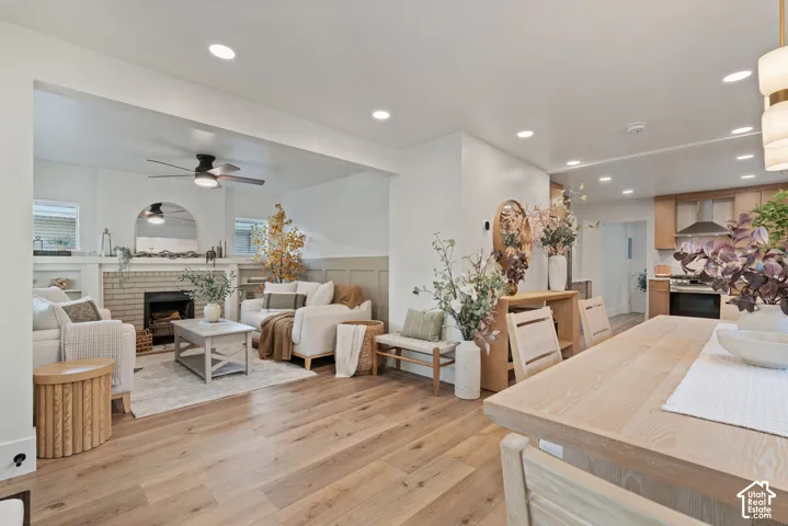 Open-concept living space featuring wood-finish flooring, recessed lighting, and a brick fireplace