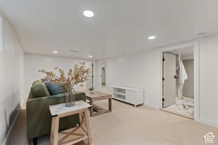 Recessed lighting, light-toned carpeting, white walls, and a doorway with a marble-style threshold