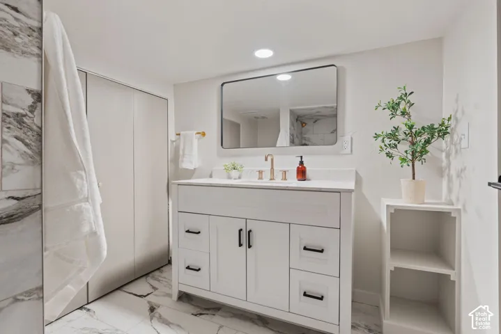 White vanity with matte black hardware, integrated sink, and light-toned countertop