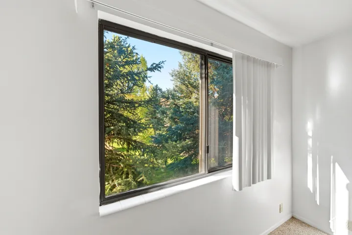 White walls with a large window and dark framing