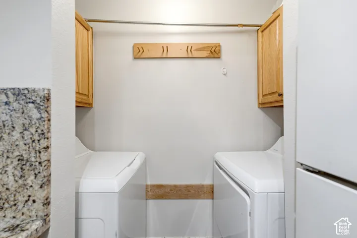 Laundry area featuring wood-finish cabinetry, a wall-mounted drying rod, and a granite-finish countertop