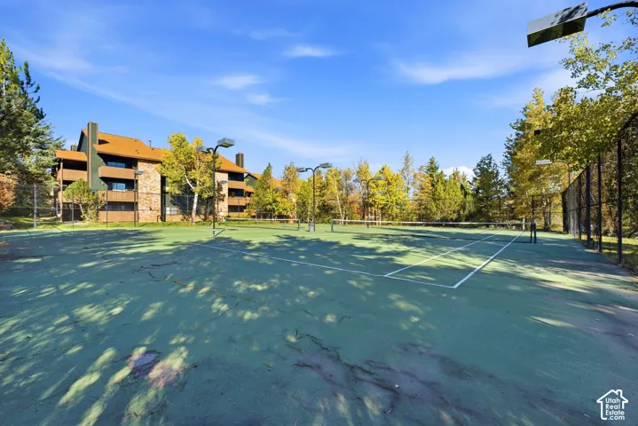 Tennis court featuring a green surface, white court lines, and multiple nets