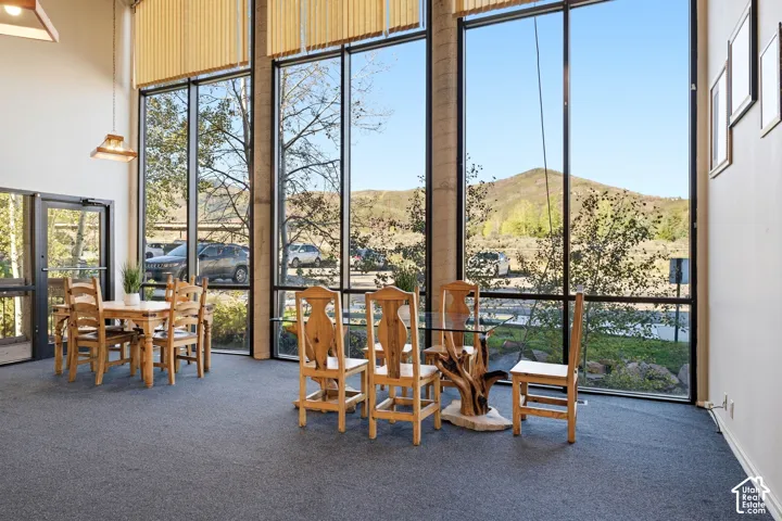 Expansive window wall with mountain scenery, natural light, high ceilings, and recessed lighting