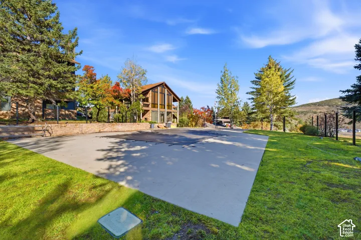 Expansive concrete patio area with surrounding green lawn
