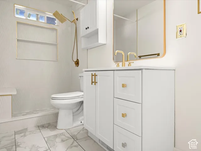 White vanity with gold hardware, integrated sink, and white countertop