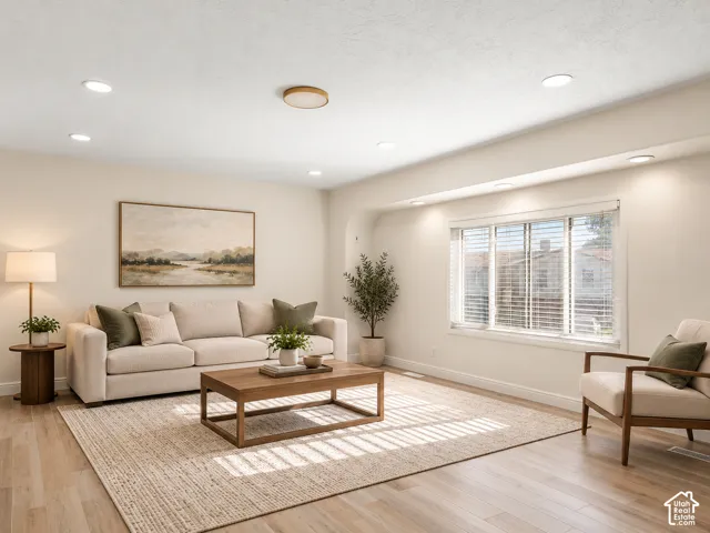 Recessed lighting throughout, wood-finish flooring, broad window with blinds, and a built-in arched alcove Virtually Staged