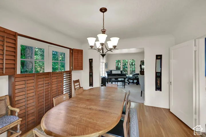 Hardwood flooring, wood interior shutters, chandelier lighting, and a wide cased opening