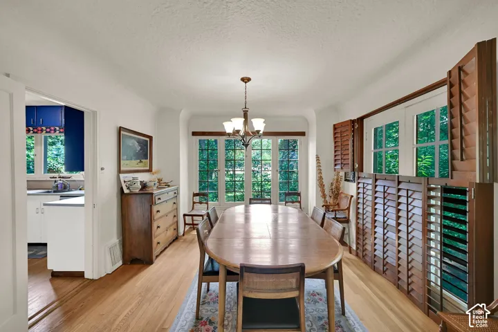 Hardwood flooring throughout, with a classic chandelier, and large windows featuring wood shutters