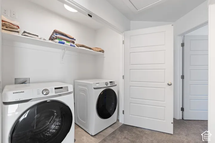 Laundry area featuring a side-by-side washer and dryer, built-in shelving, recessed lighting, and a paneled door