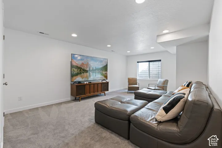 Recessed lighting, wall-to-wall carpeting, and a window with horizontal blinds