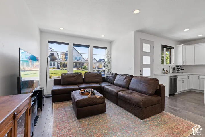 Open-concept living area with large windows, recessed lighting, and wood-finish flooring