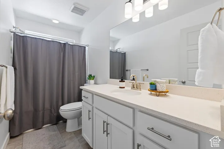 Vanity with an integrated sink, broad mirror, and contemporary light fixture