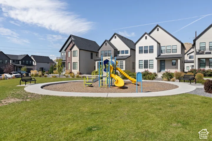 Community green space featuring a playground, benches, and landscaping