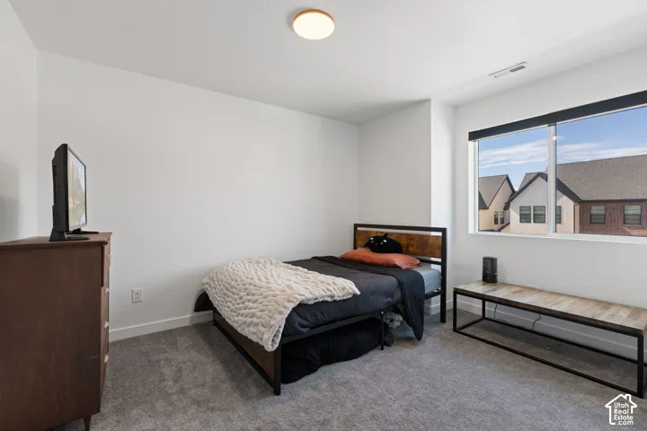 Recessed window with black roller shade, gray carpet flooring, and a flush-mount ceiling light fixture