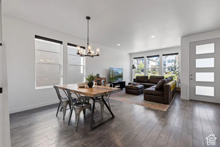 Open-concept living space featuring wood-finish flooring, recessed lighting, and a modern chandelier