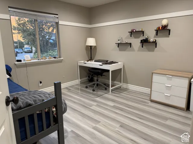 Light-toned wood-finish flooring complements the neutral wall color