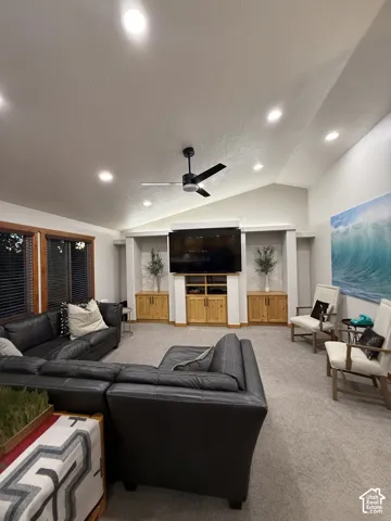 Vaulted ceiling with recessed lighting, ceiling fan, and built-in entertainment center