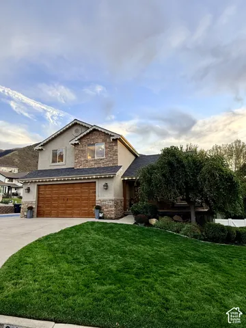 Stucco and stone exterior with a wood-finish garage door