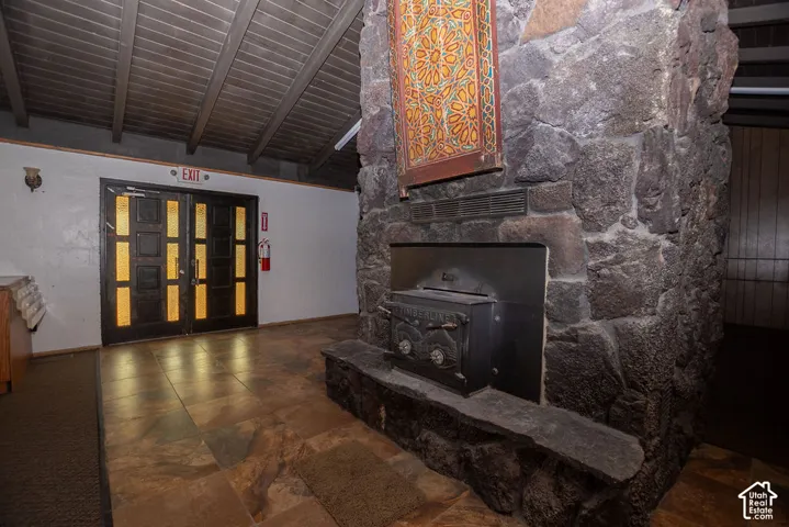 Stone fireplace with a wood-burning stove insert and stone hearth