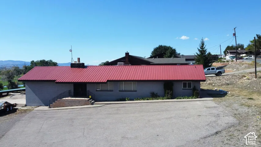 Red metal roof and a light-colored exterior finish